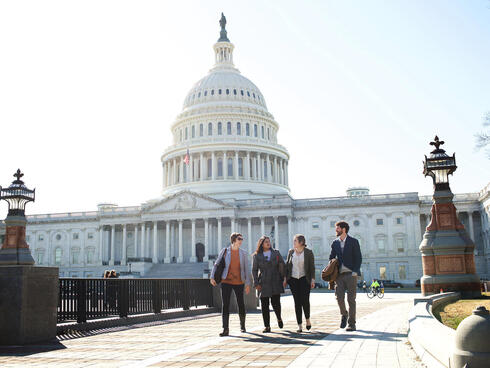 Four Lobby Day participants walk in front of the United States Capitol Building.