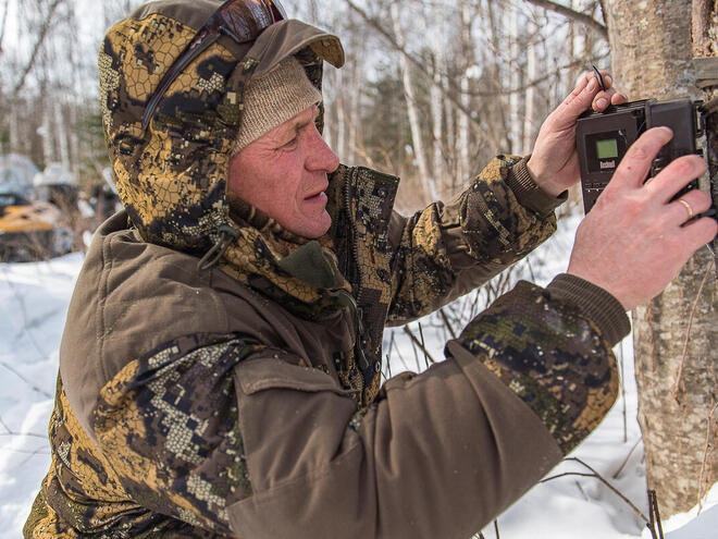 Ranger Andrei Kortjak sets up a camera trap in the snows of Anuiksky National Park, Russia