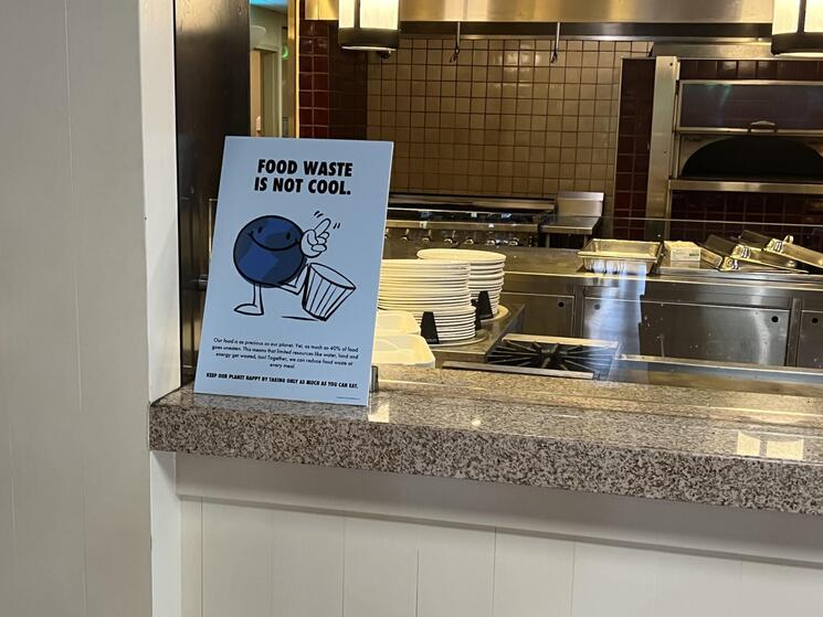 Sign by a serving station reading "food waste is not cool"
