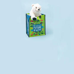 Product shot of a polar plush in a reusable WWF gift bag in front of a light blue backdrop.