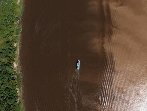 Aerial view of Amazon river with small boat at a distanc
