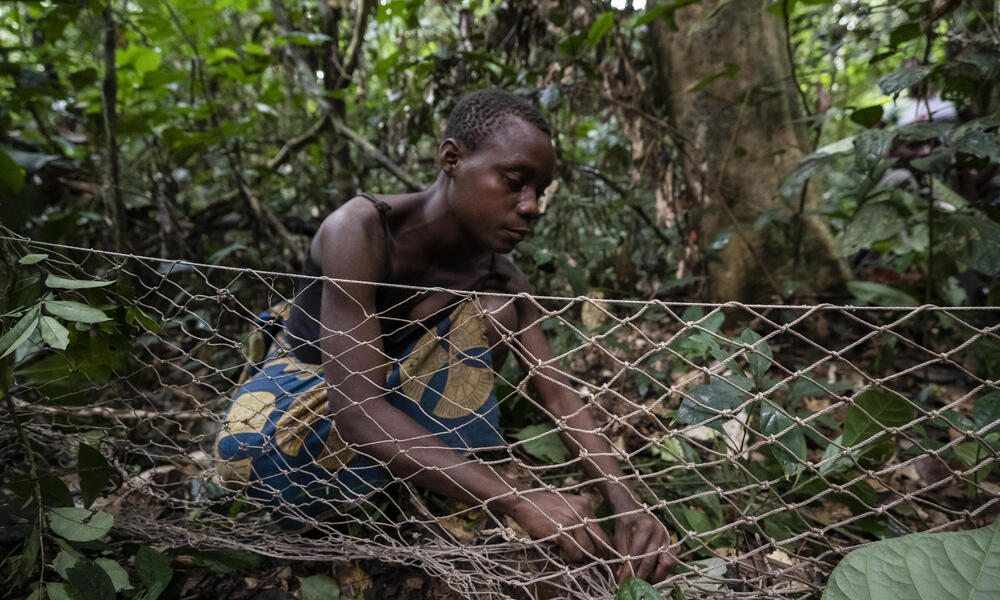 Guemou, part of a group of BaAka people living around the Dzanga-Sangha Special Reserve, prepares a hunting net