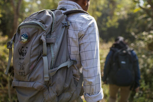 Person facing away wearing backpack with WWF logo