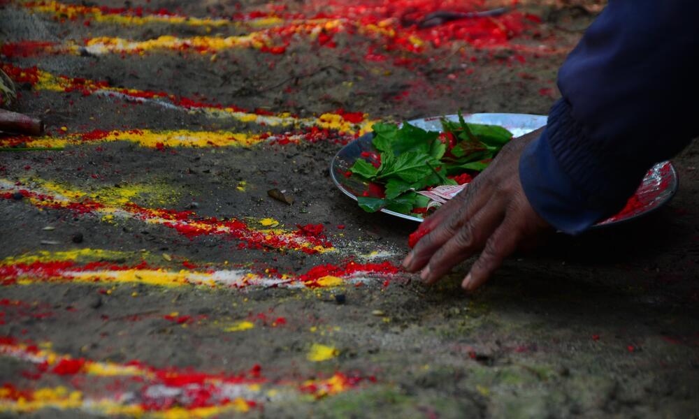 Red, yellow, and white powder spread in lines on dirt ground