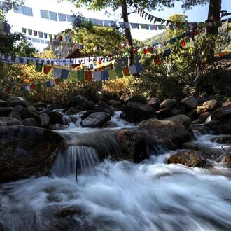 Prayer flags hang above a large river