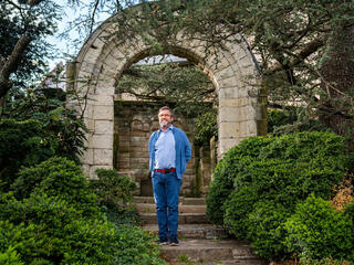 Moreno stands beneath a garden arch
