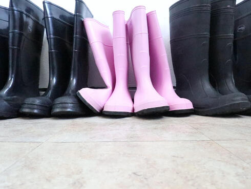 A pair of pink rubber boots at a processing plant