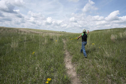 Boy runs through grasslands of his family ranch