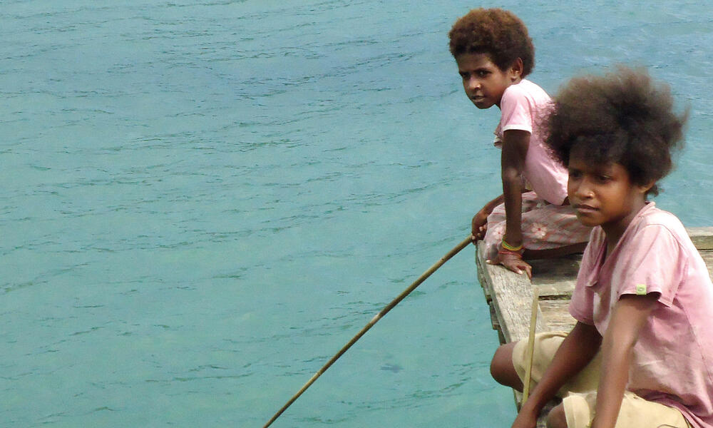 Boys on a dock in Bird's Head Seascape, West Papua, Indonesia