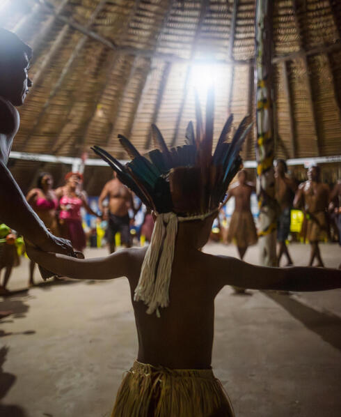 A child in traditional dress dances in circle with others