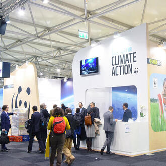 People walk around the Climate Action Center at COP 23