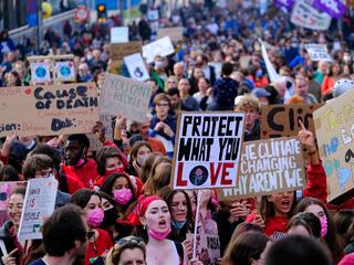 A large group protesting in the street holding signs