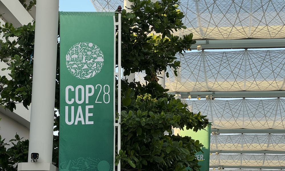 A vertical green sign reads COP28 at a building in Dubai
