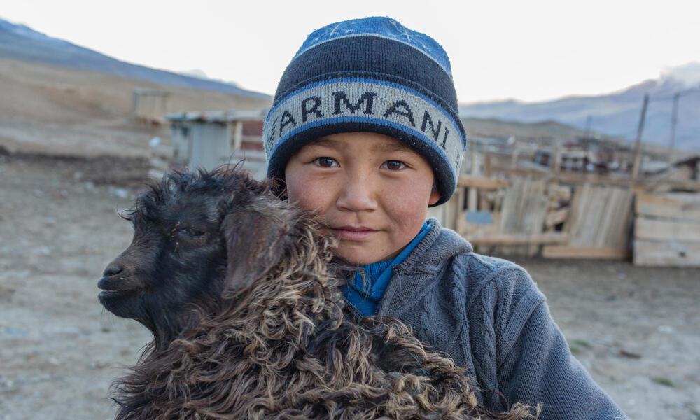 Child holding a goat in Ak-Shyrak, Kyrgyzstan