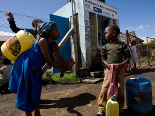 Children collect water at a kiosk in Kenya