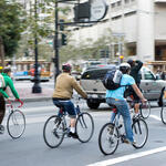 Environmentally conscious bikers cycling in traffic in San Francisco, California, United States of America.