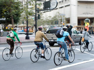 Environmentally conscious bikers cycling in traffic in San Francisco, California, United States of America.