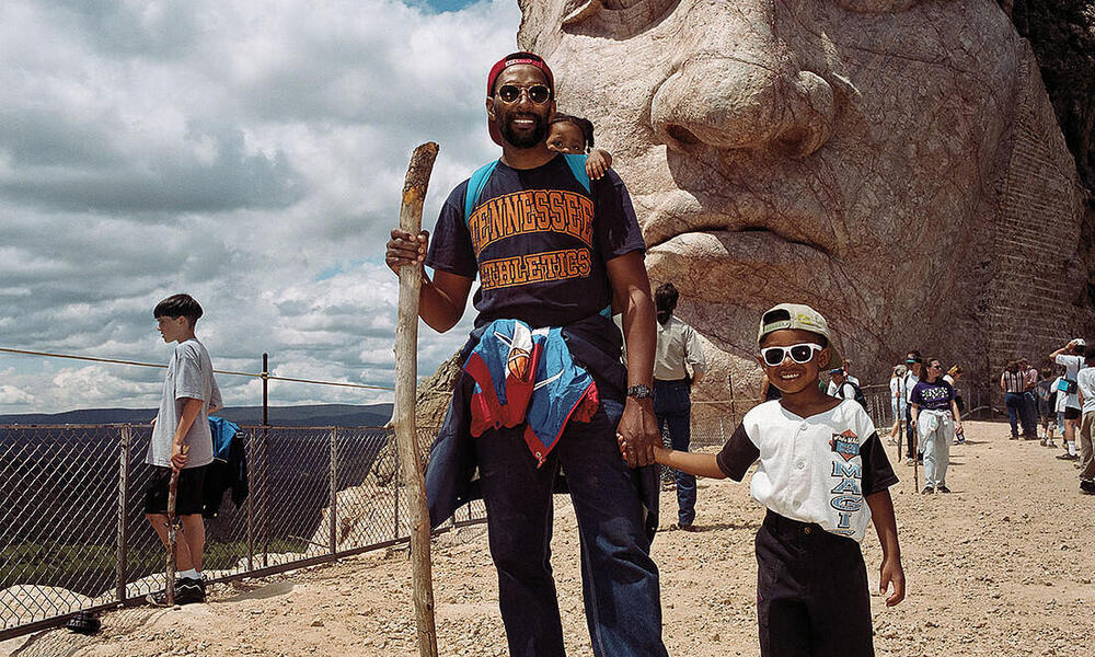 A man and his son pose in front of Crazy Horse Memorial