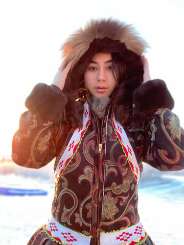 Allie Ivanoff looks straight at the camera in a large parka in the snow