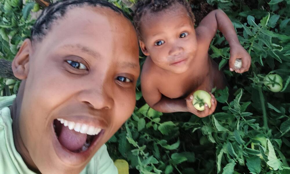 Selfie of Koba Kxoara smiling with young child