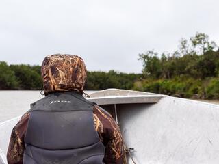 Dana Okitun, son of Marvin Okitun, looks ahead from bow of boat on Yukon River