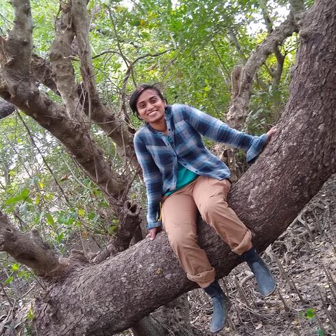 WWF Scientist Dina Rasquinha sits on a tree branch