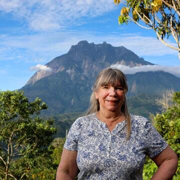 Image of Dr. Kathy MacKinnon in front of Mt. Kinabalu