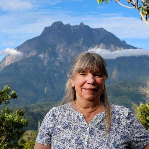Image of Dr. Kathy MacKinnon in front of Mt. Kinabalu