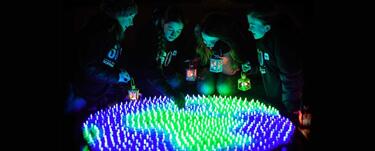 Earth Hour participants surruond a glow in the dark globe