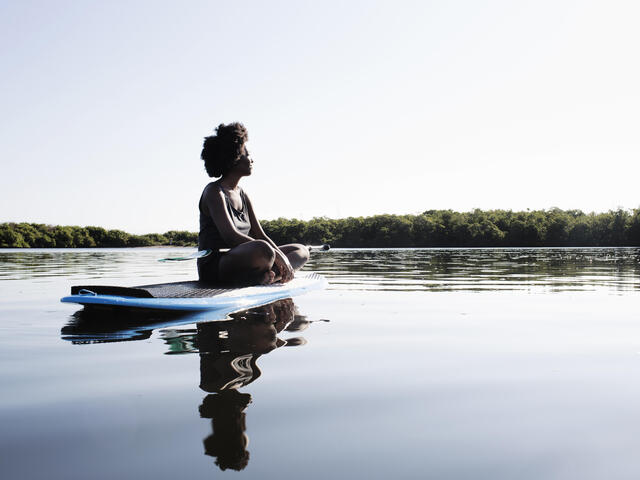 A person on a paddle board in the middle of a lake