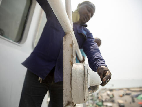 Richard Ahene Niunoo (Second Officer) inspects a Satlink camera, an on-ship camera system on a boat.