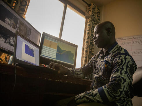 Richard Yeboah sits in front of a computer reviewing information from electronic monitors