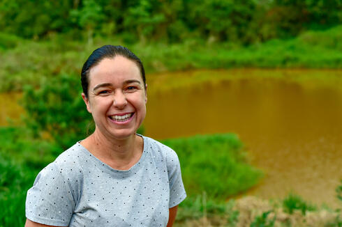 Portrait of Ellen Fontana standing on her lush, green coffee farm