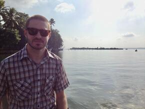 Evan in front of a forest and river landscape