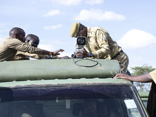 A person affixes a FLIR camera to the roof of a truck on a sunny day