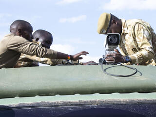 A person affixes a FLIR camera to the roof of a truck on a sunny day