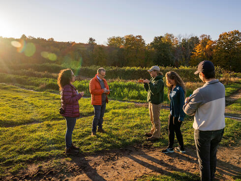 Group of people talking together in a a farm field