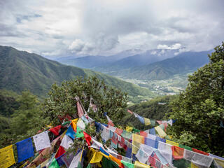 Flags hanging from ropes over mountain landscape