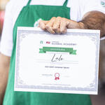 A person displays their Starbucks Greener Apron certificate