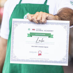 A person displays their Starbucks Greener Apron certificate