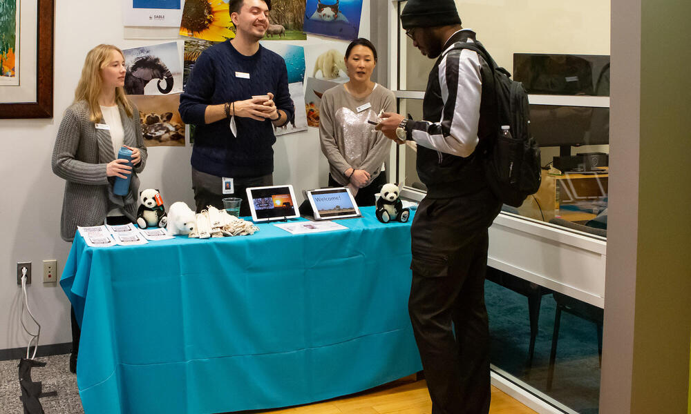 A student talks to members of the wildlife team at the HBCU Career fair