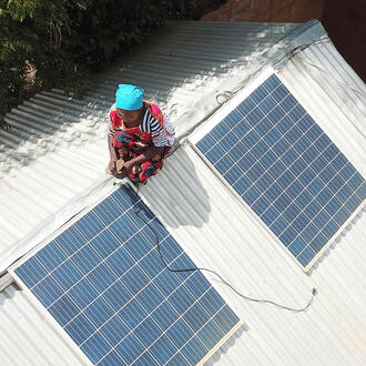 Woman on roof adjusting solar panels