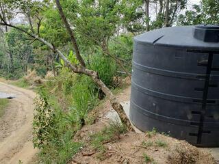 A large black water tank sitting atop a hill in Honduras