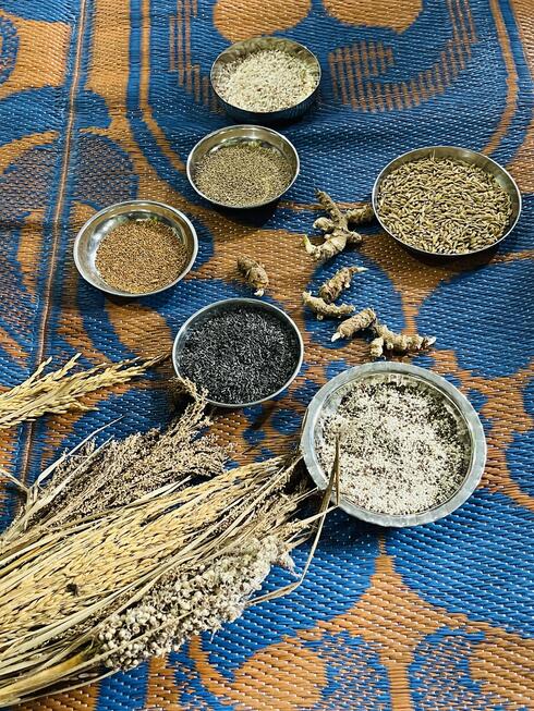 Various powders sit inside colorful bowls on a carpet