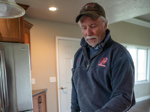 Rancher Joe Russell points to a map on his counter.