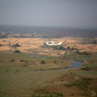 A small plane flying over the African landscape