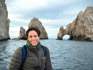 Lauren Tyler standing on coast near rock formations