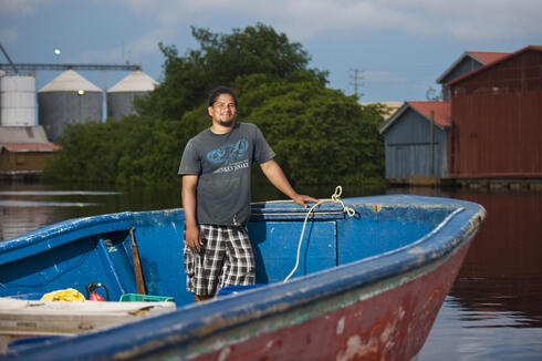 Belize City fisherman Levan Aldama stands in his boat