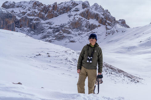 A man standing in snow with his camera