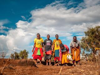 A group of women from the Maasai Lemong’o Women’s Vision spread grass seeds over earth bunds